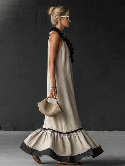 Vestido largo sin mangas crema con volantes negros en el escote y falda acampanada