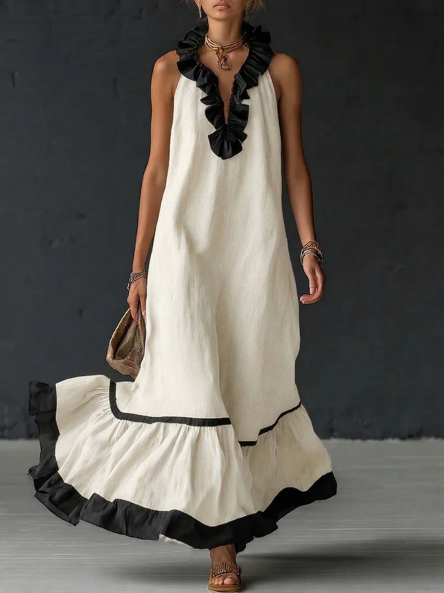 Vestido largo sin mangas blanco roto con volantes negros en el escote y borde inferior