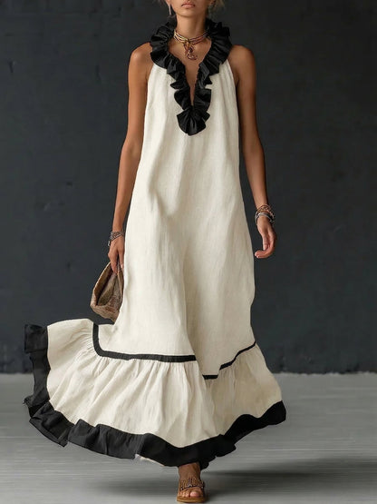 Vestido largo sin mangas blanco roto con volantes negros en el escote y borde inferior