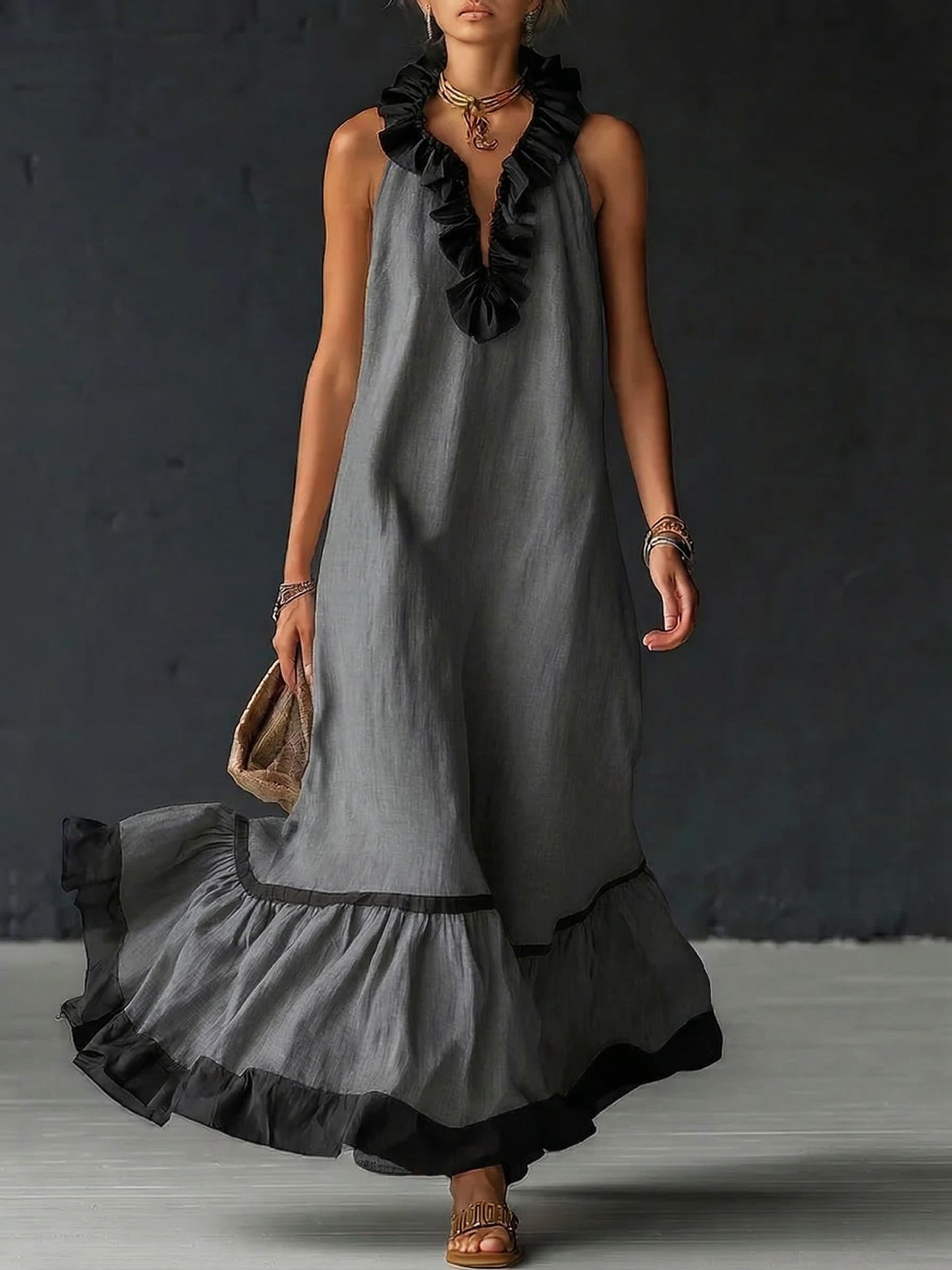 Vestido largo sin mangas gris con volantes negros en el escote y falda con ribete