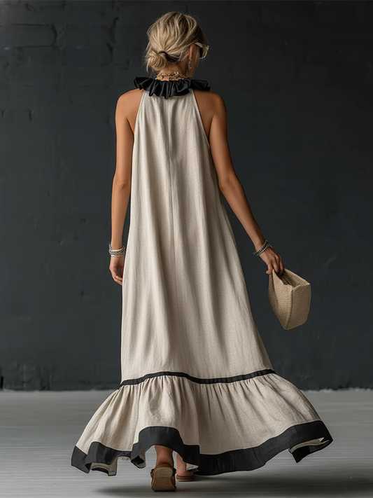 Vestido largo sin mangas color crema con volantes negros en el escote y dobladillo