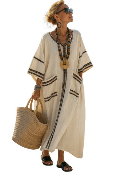 Vestido caftán tono claro con detalles en azul marino, cuello con abertura y mangas tipo kimono.