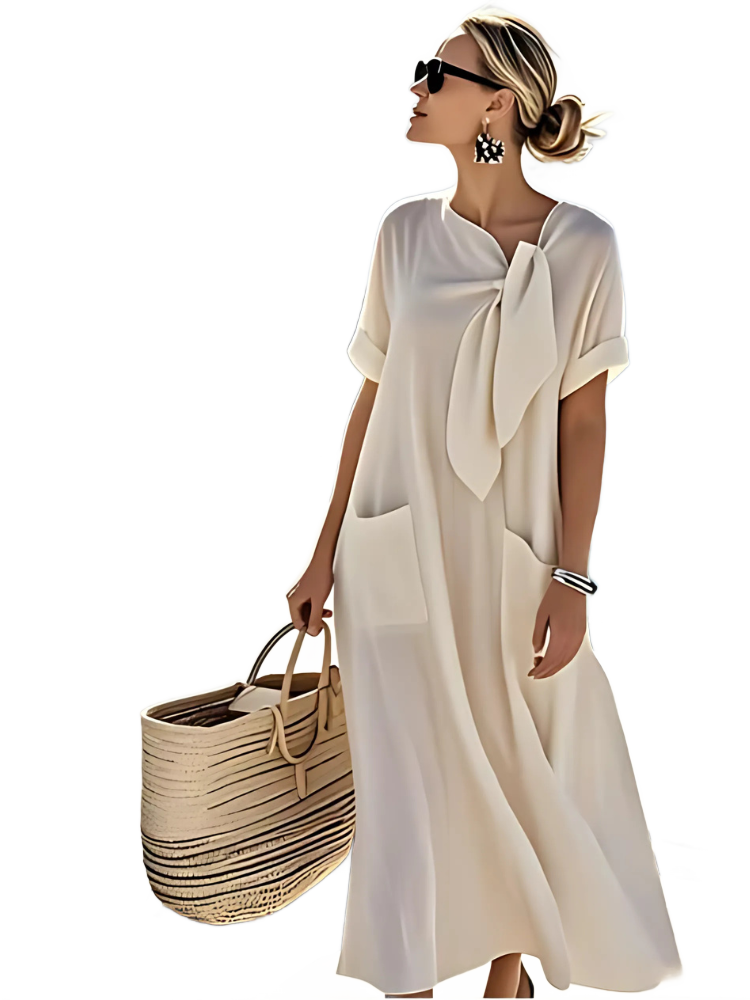 Vestido blanco roto con lazo al cuello y bolsillos laterales, manga corta.