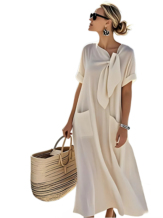 Vestido blanco roto con lazo al cuello y bolsillos laterales, manga corta.
