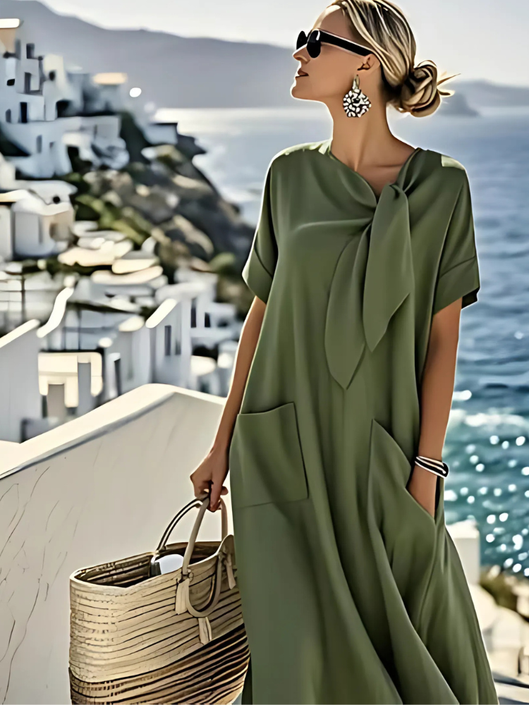 Vestido verde caqui con lazo en el cuello y bolsillos laterales, manga corta.