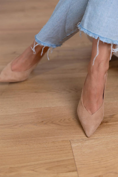 Zapatos de tacón bajo beige con punta fina y tacón fino, vista frontal.