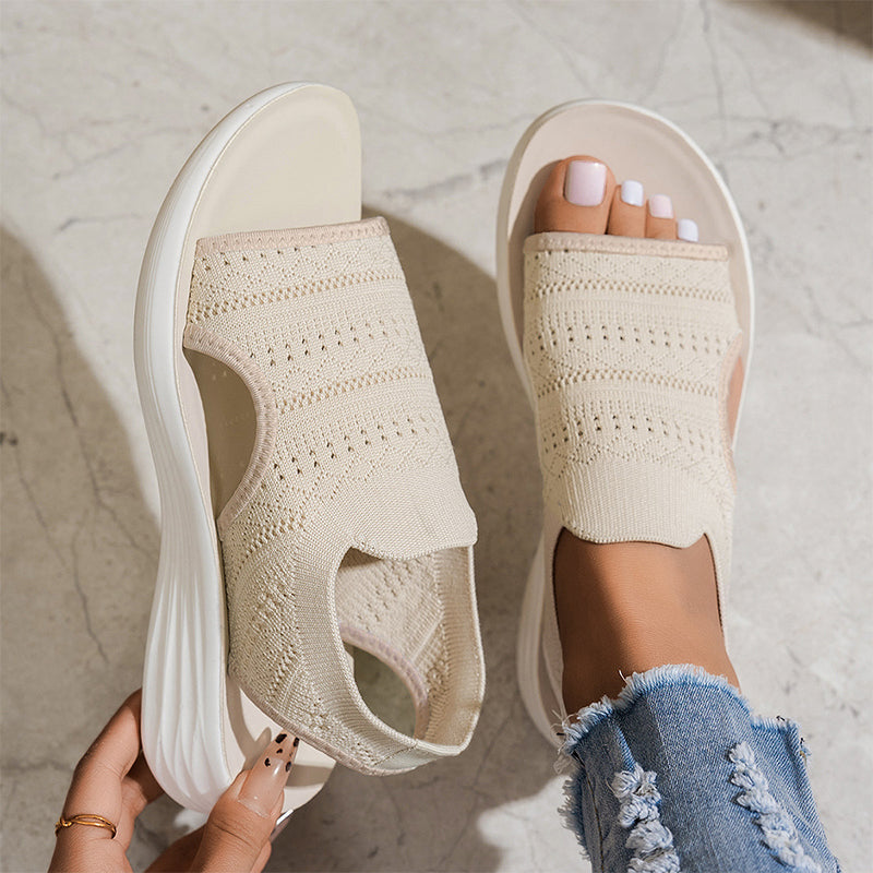 Sandalias ortopédicas de tejido beige en pies, punta abierta y suela blanca acolchada