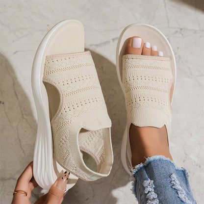 Sandalias ortopédicas de tejido beige en pies, punta abierta y suela blanca acolchada